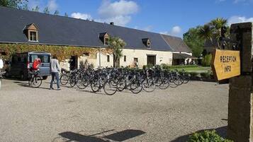 A building with a gravel driveway, bicycles parked in front, and a reception sign.