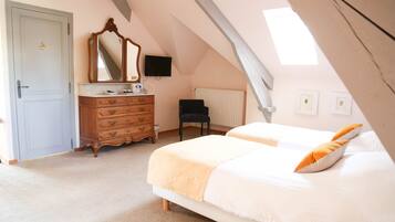 A bedroom with two beds, a dresser, a chair, a television, and a window with natural light.