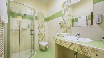 Un bagno con doccia vetro, toilette e lavabo con specchio sopra.