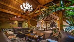 A spacious lounge area with leather sofas, a wooden coffee table, and a chandelier. - Wellness hotel SPARK (Plavecký Štvrtok)