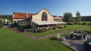 A hotel with a large patio area, outdoor seating, and a Coca-Cola branded awning. - Wellness hotel SPARK (Plavecký Štvrtok)