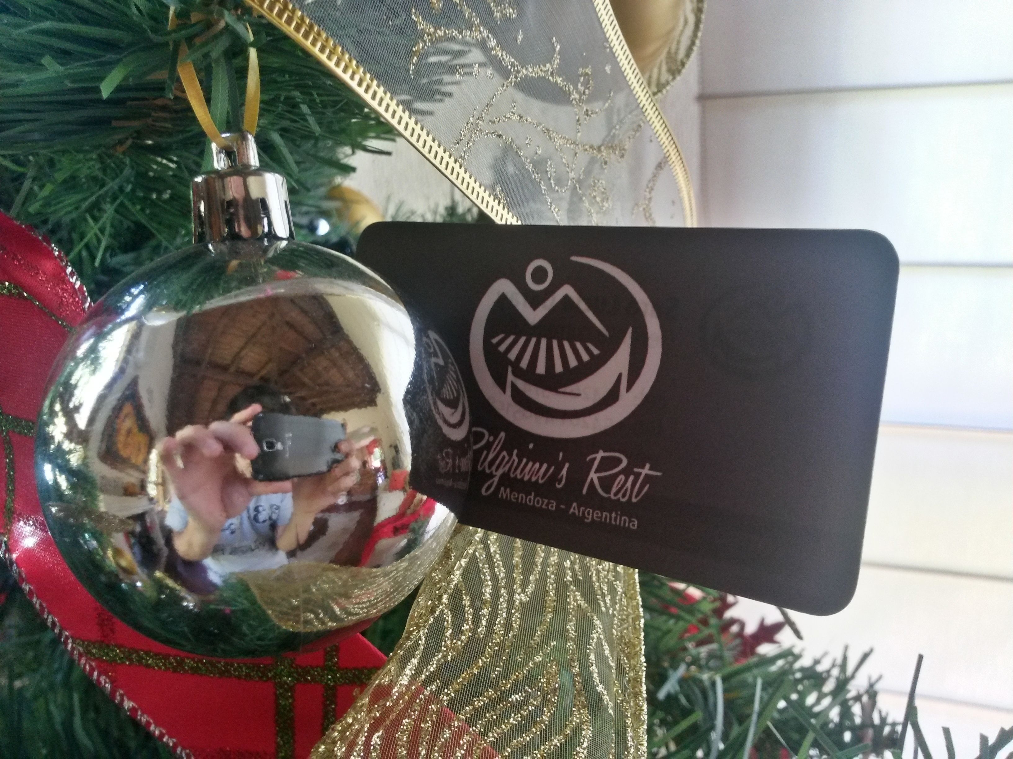 A Christmas ornament and a business card with a logo and text.