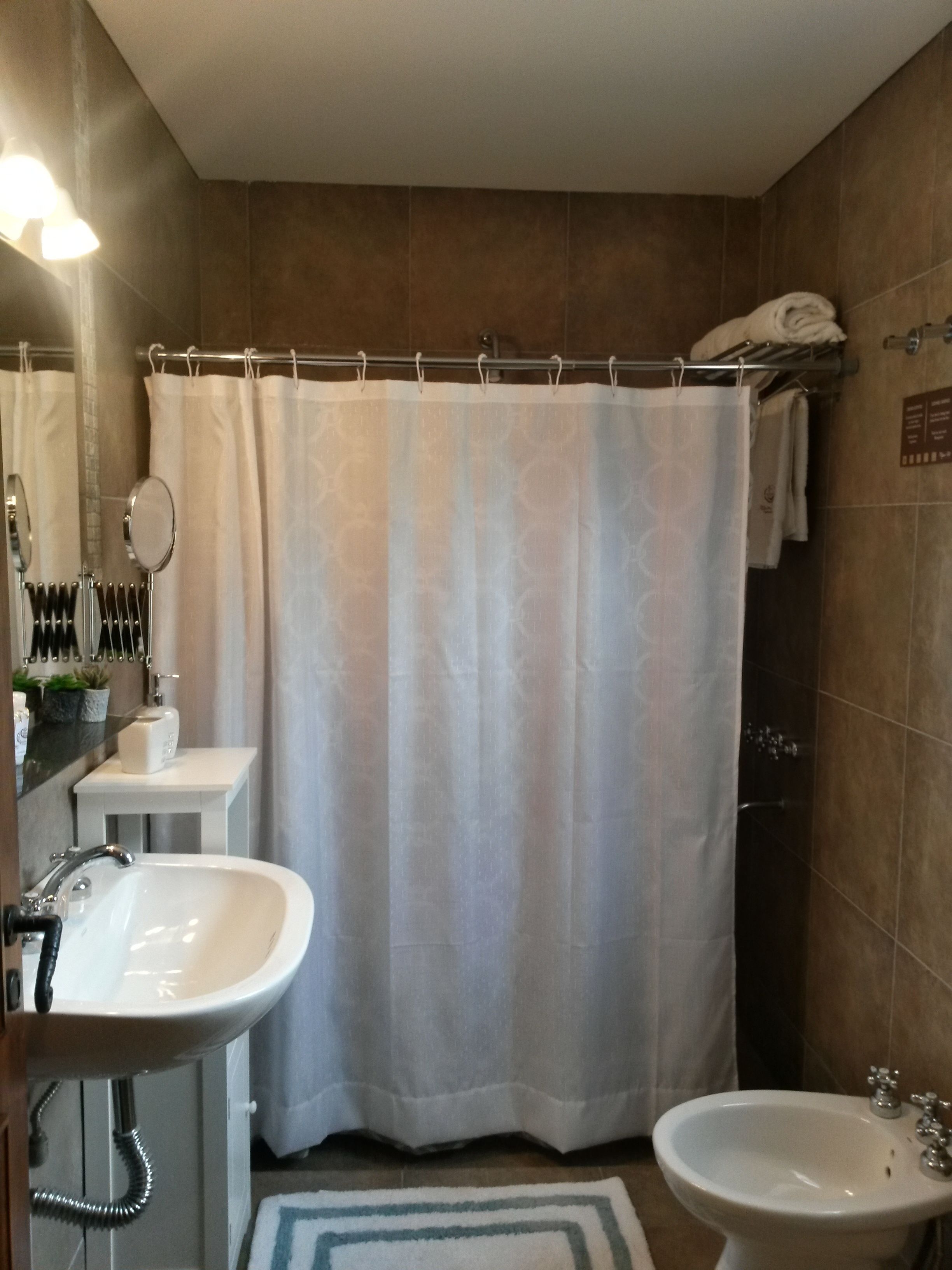 Un baño con cortina de ducha, lavabo, bidé y espejo.
