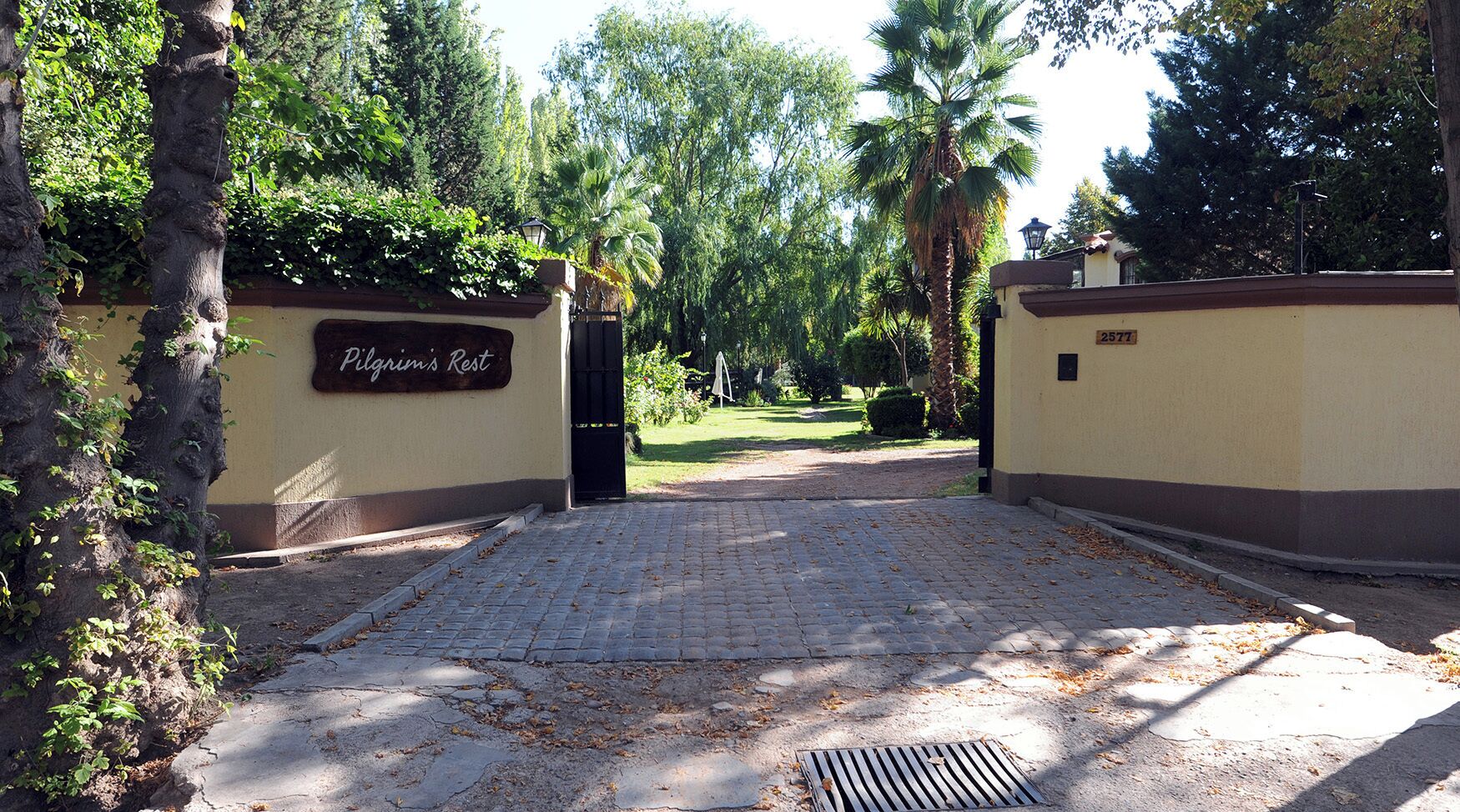 A paved entrance to a property with a sign reading "Plarimar's Rest."