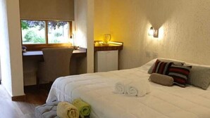 A bedroom with a large bed, a desk, and a window. - Pilgrim's Rest (Chacras de Coria)