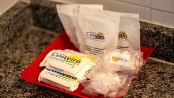A red tray with toiletries including a bar of soap and two packets of lotion.