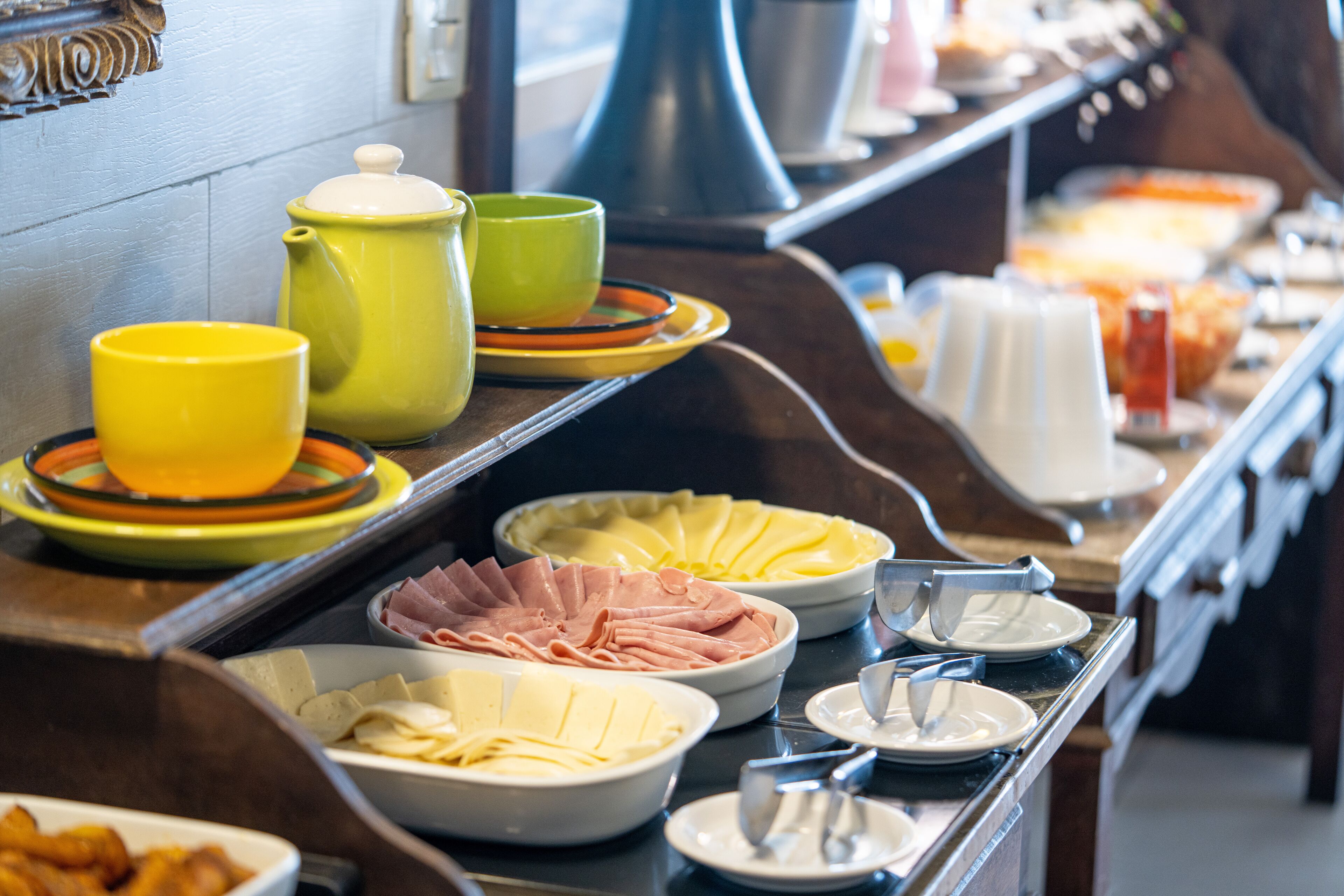 A buffet with various food items and utensils.