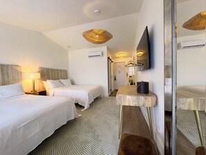 A hotel room with two beds, a mirror, a flat-screen TV, and a small table. - The Montauk Beach House (Montauk)