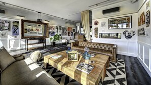 A modern living room with a leather sofa, a wooden coffee table, and a large mirror.