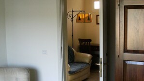 Une pièce comprenant un lit, une chaise, un canapé et une porte en bois.