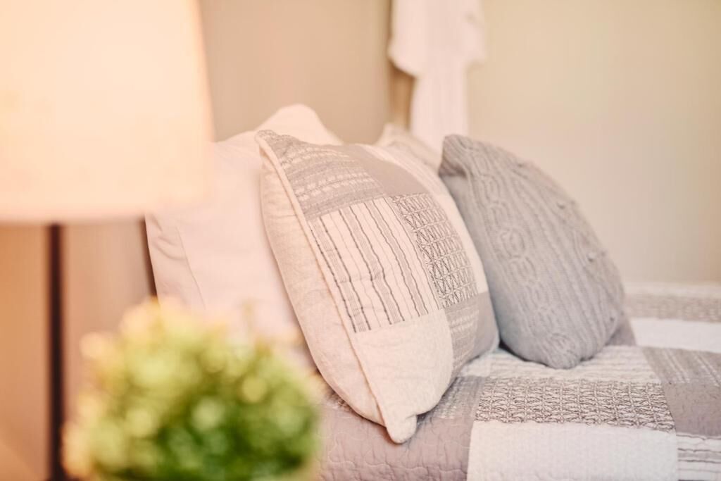 Una cama con una colcha estampada y almohadas.