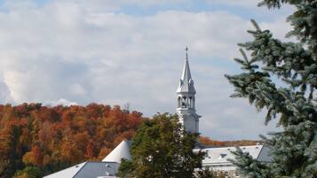 A church with a steeple, surrounded by autumn-colored trees.
