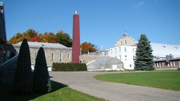A building with a tall red chimney, a greenhouse, and a well-maintained lawn.