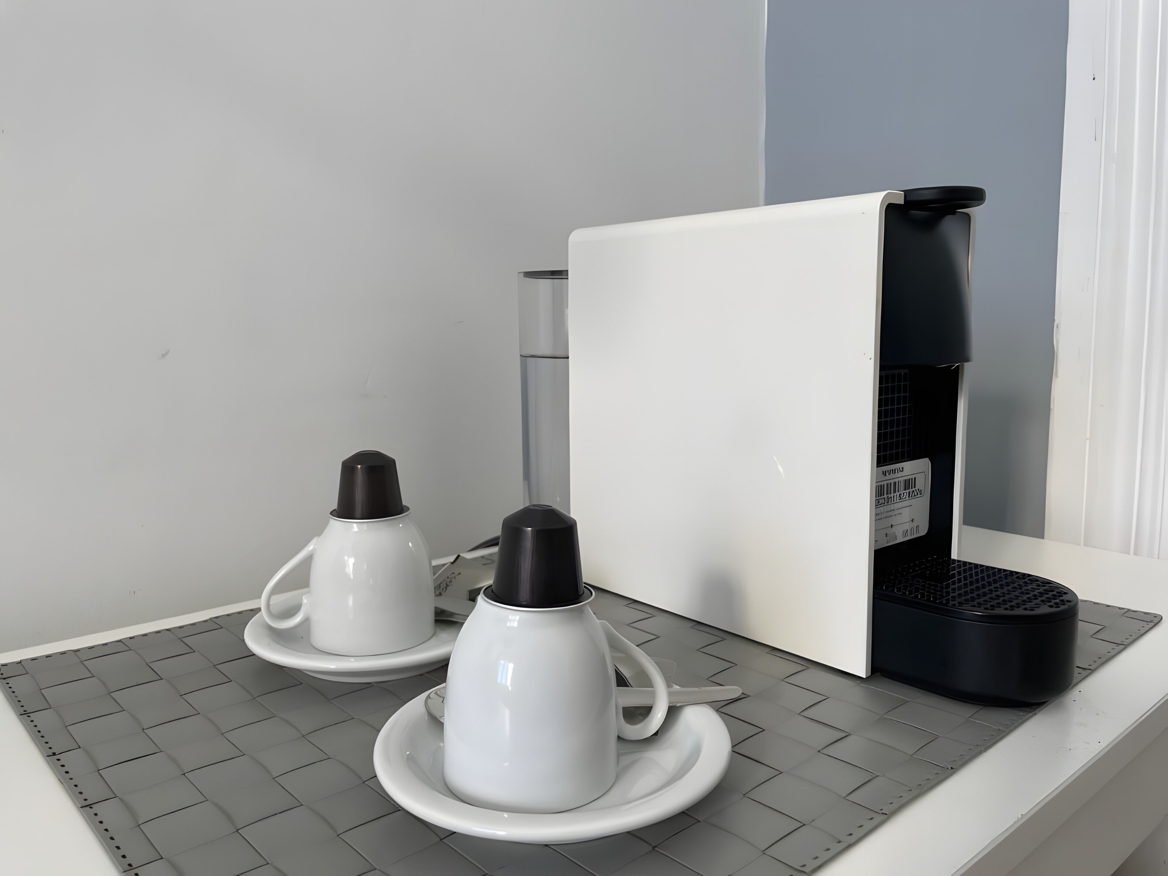 A kitchen area with a coffee maker, a kettle, and a microwave on a countertop.