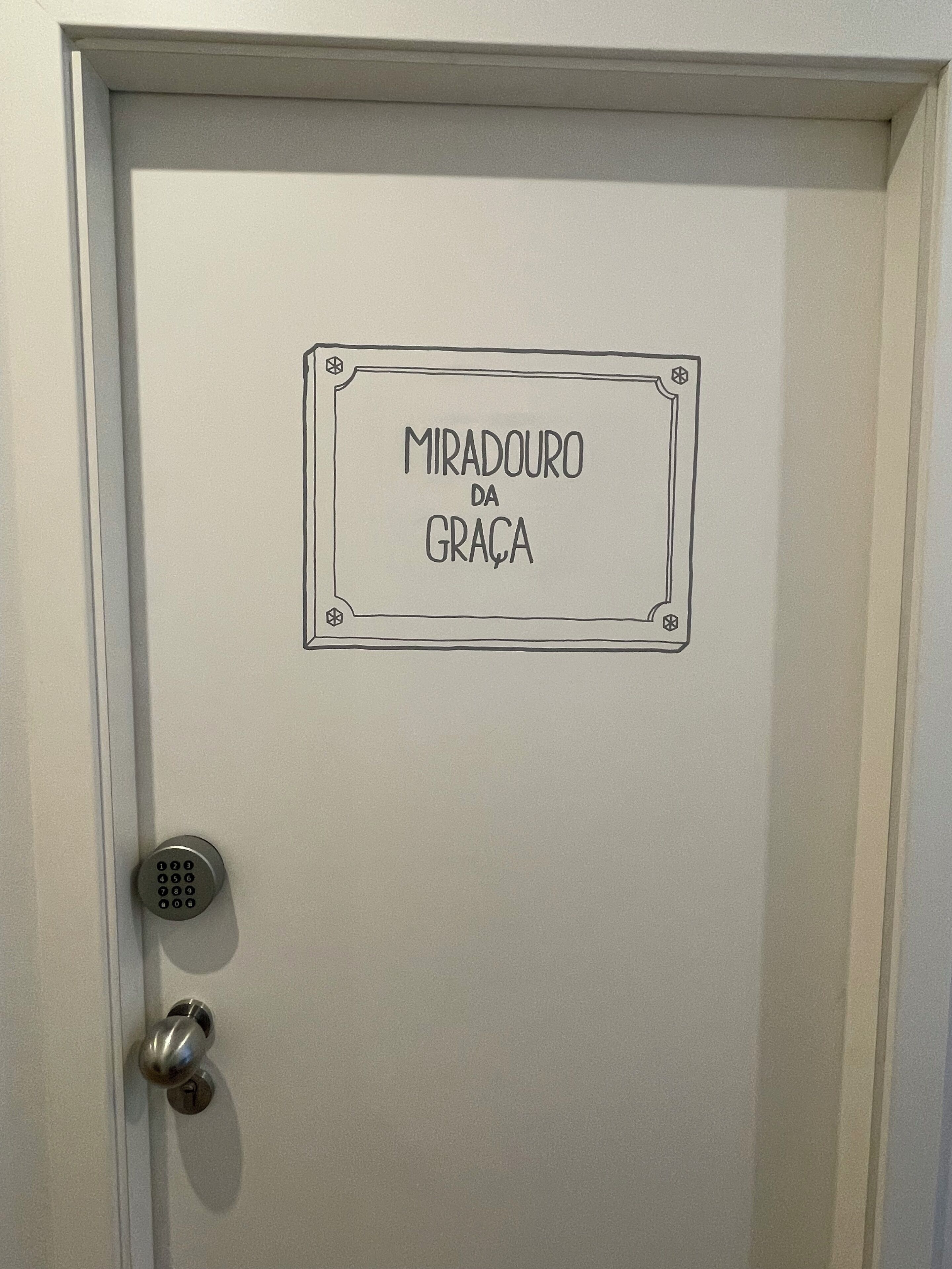 Une porte avec une plaque portant l’inscription « MIRADOURO DA GRAÇA » et un trou de serrure.