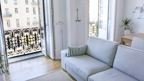 A modern living room with a sofa, a small table, and a potted plant. - Lisbon Check-In Guesthouse (Lisbon)