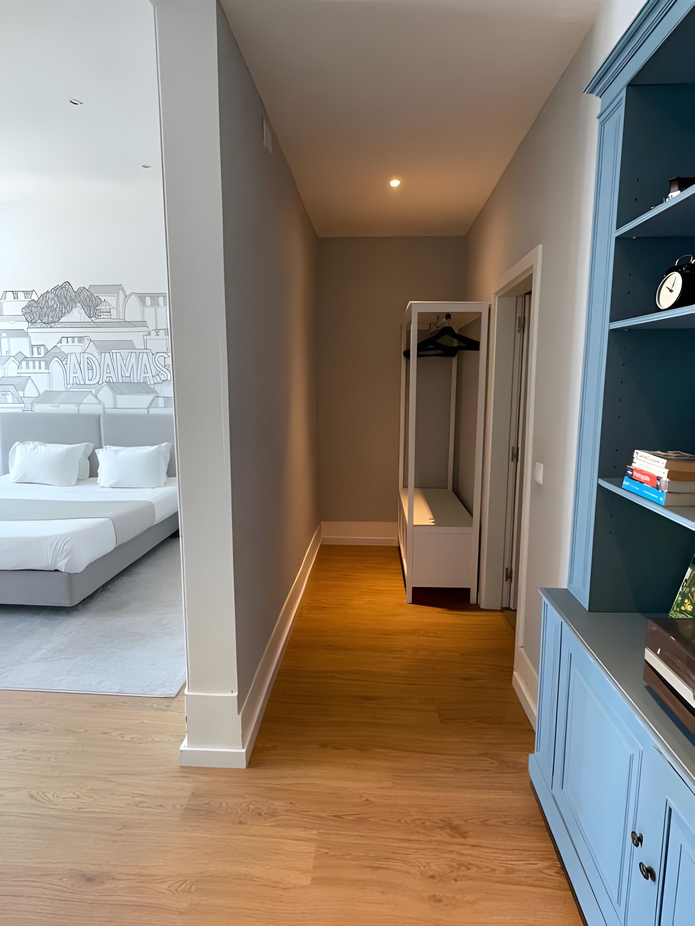 Een slaapkamer met een bed, een kledingkast en een gang naar een inloopkast.