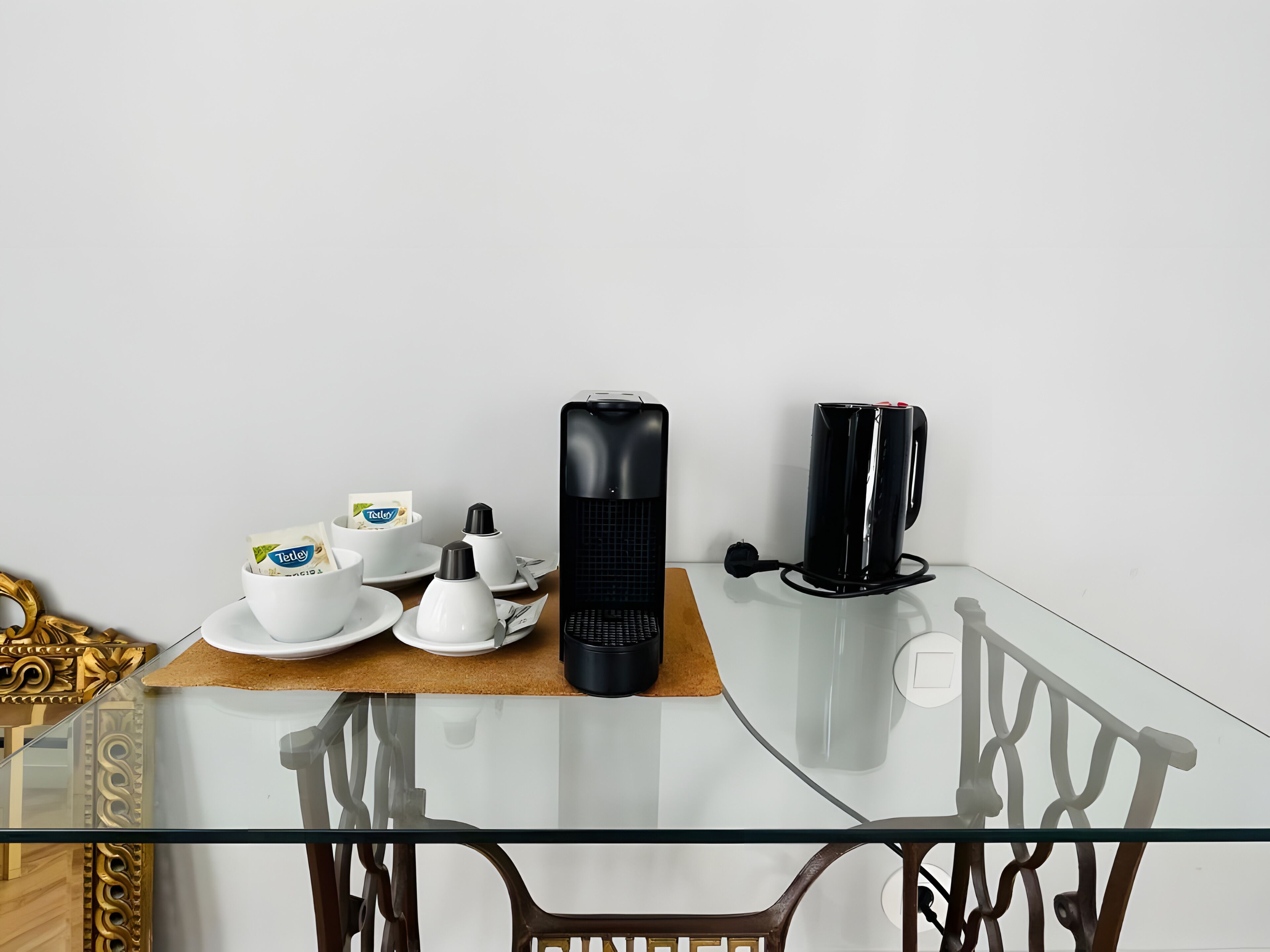A dining table with a coffee maker, a mug, and a box of Telfy tea.