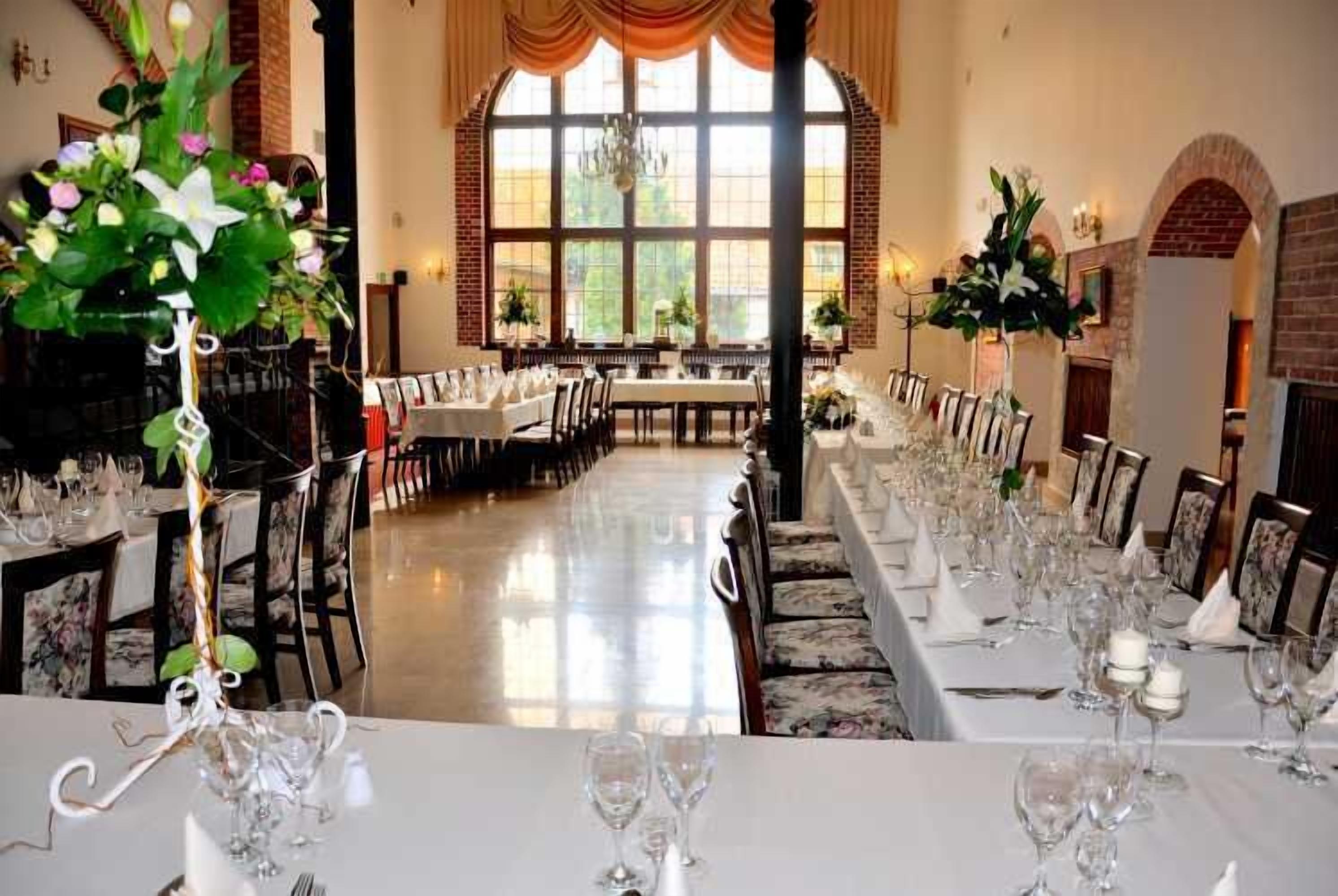 A long dining table set for a formal event with chairs and glassware.
