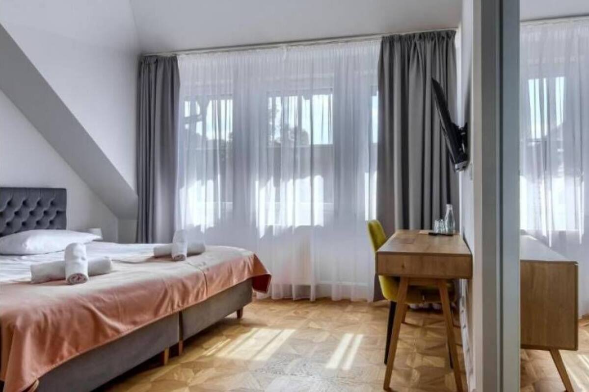 Quarto com cama, escrivaninha e cadeira.