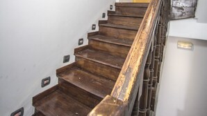 Un escalier en bois, muni d’une rampe, mène à une porte située en haut.