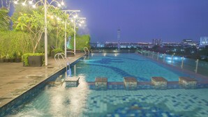 A swimming pool with a view of a cityscape at dusk. - Best Western De Papilio (Surabaya)