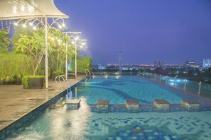 Alberca al aire libre y camastros 