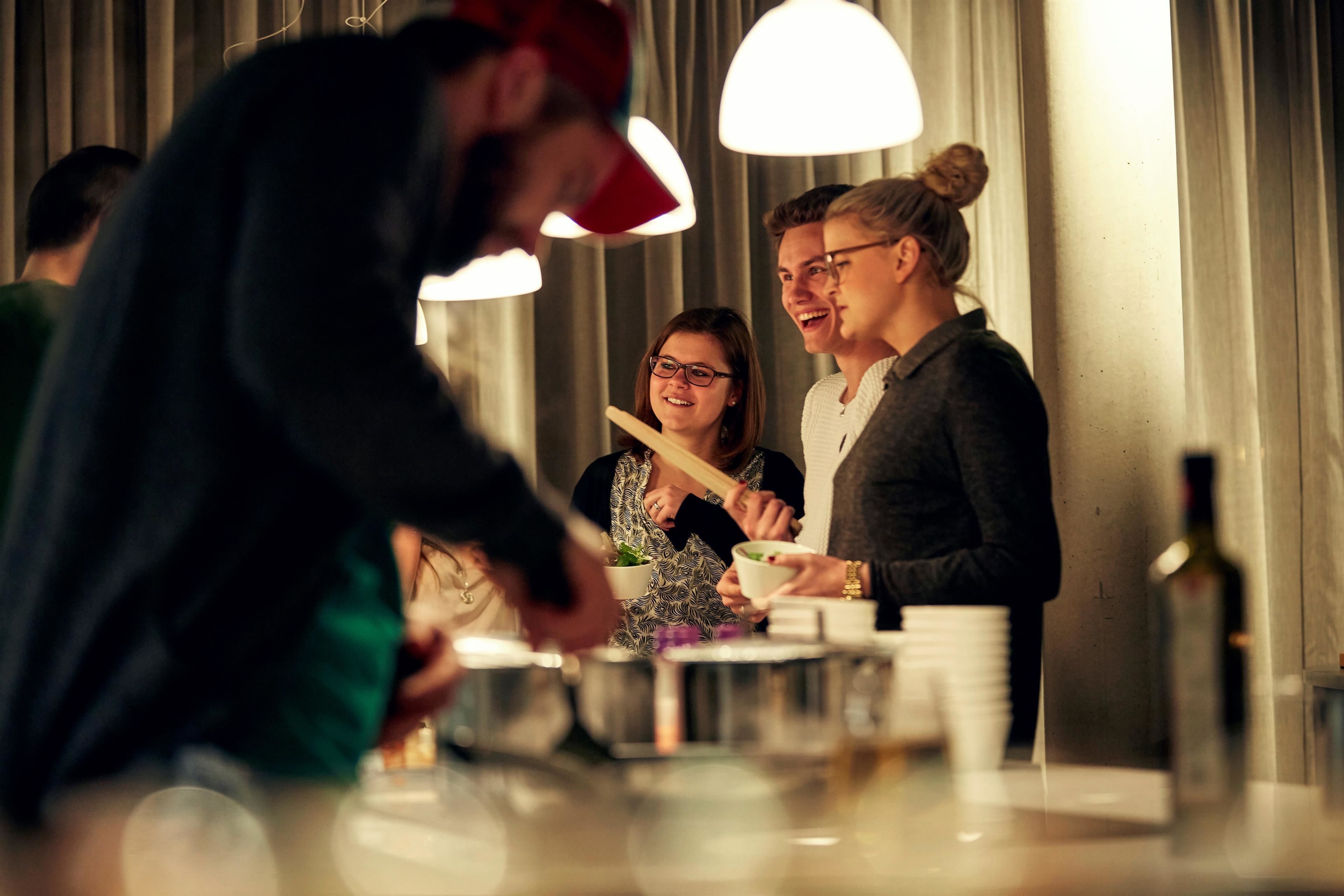 Een groep mensen dineert in een modern restaurant met een bar.