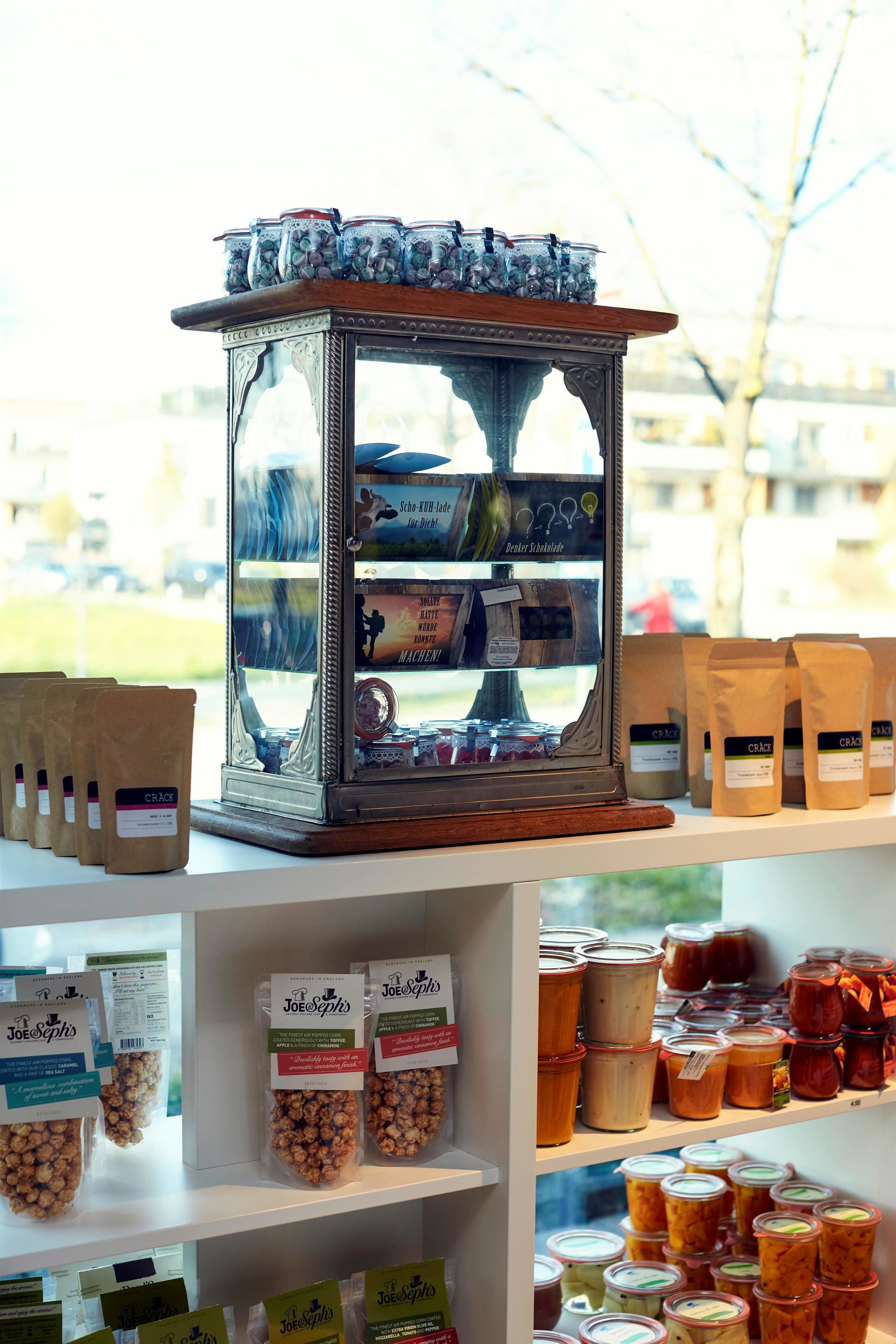A display of various packaged goods, including snacks and preserves, arranged on shelves and a central display case.