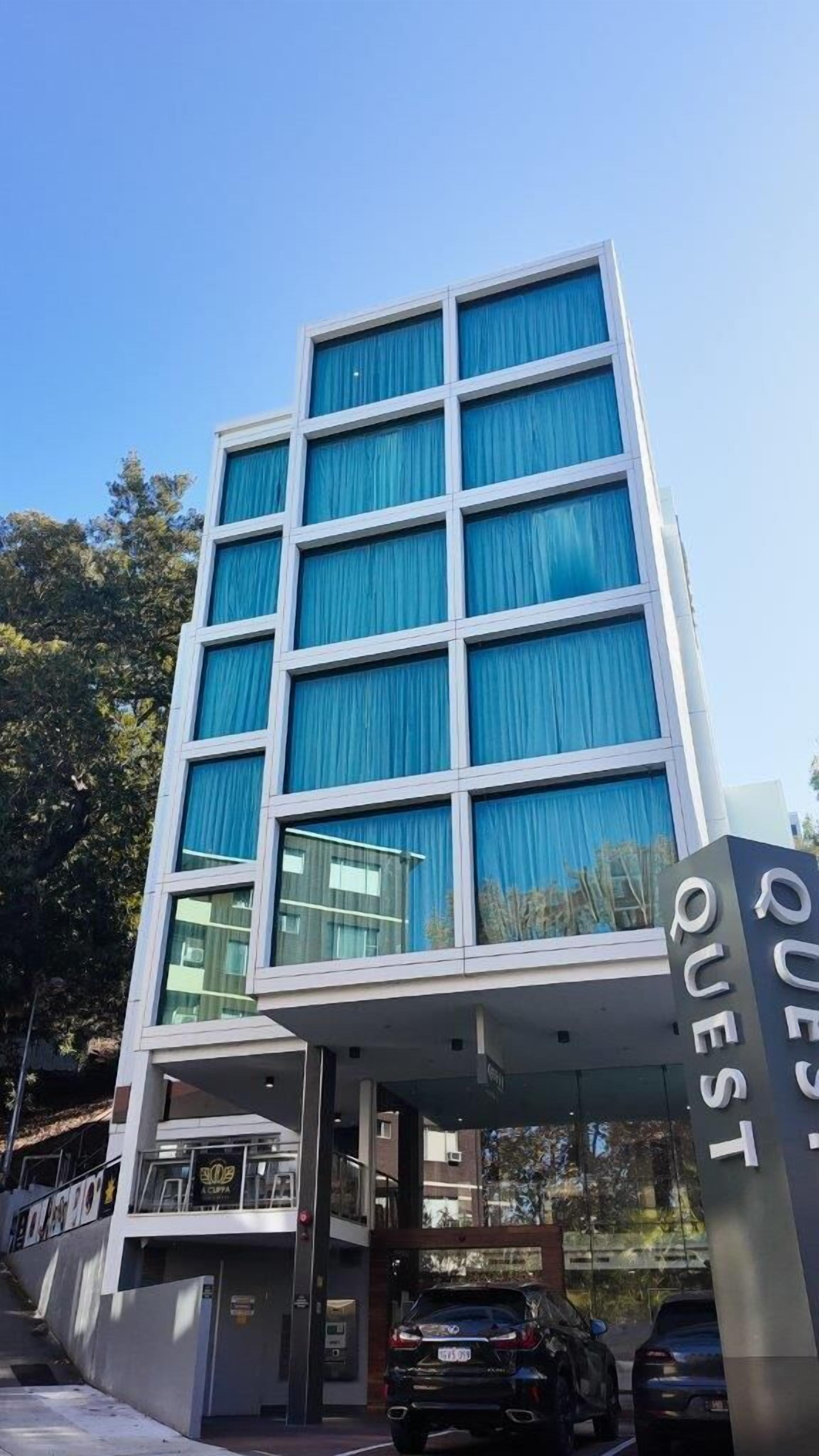 A modern building with a prominent entrance labeled "QUEST."