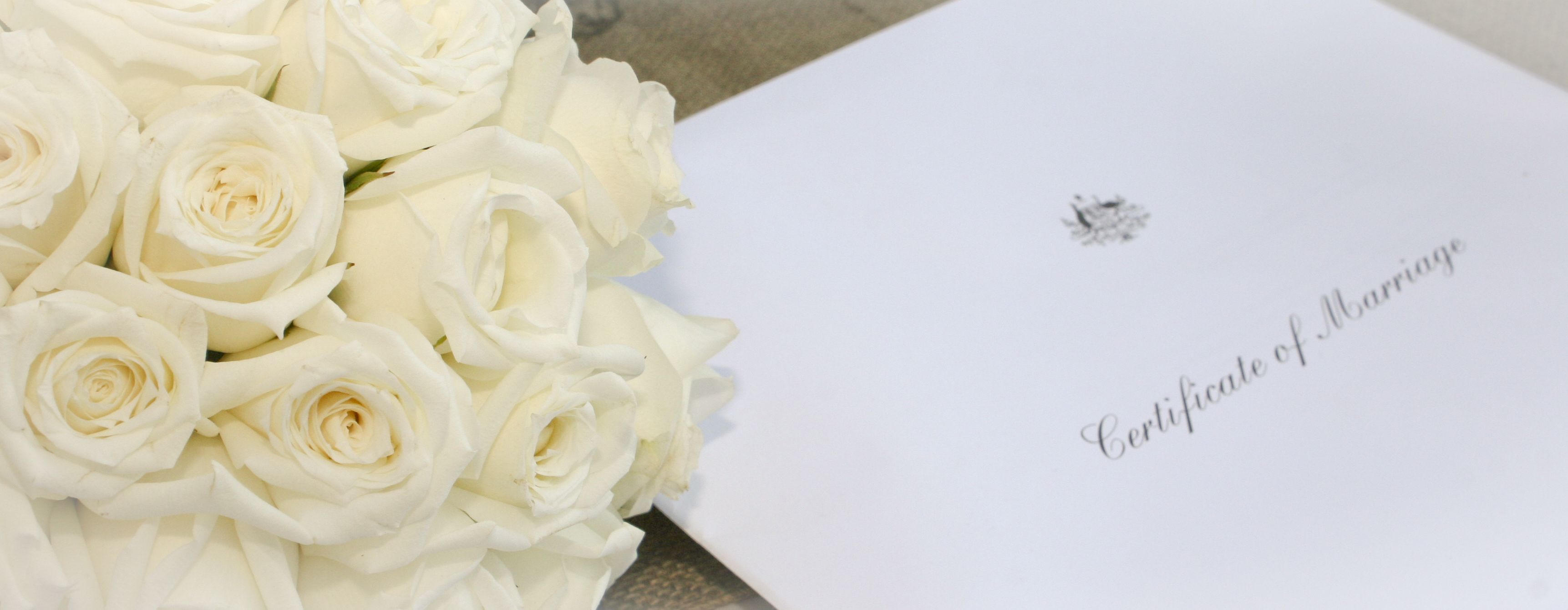 A bouquet of white roses and a certificate of marriage.