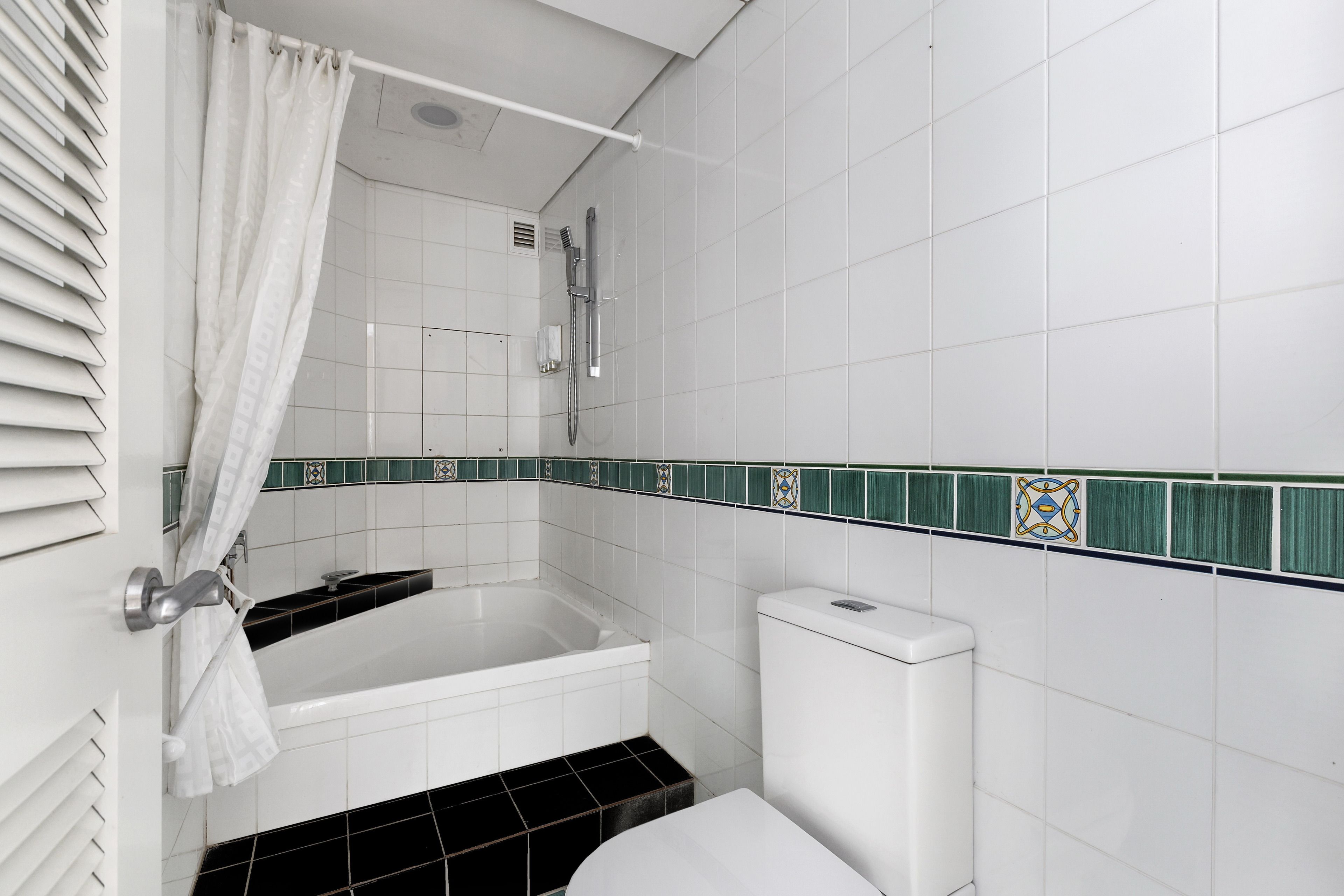A bathroom with a bathtub, toilet, and shower.