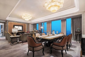 A spacious dining area with a long table, multiple chairs, and decorative vases. - Wanda Reign Chengdu Hotel (Chengdu)