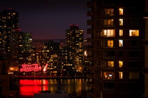A nighttime cityscape with illuminated buildings and a river. - The Bernic Hotel New York City, Tapestry Collection by Hilton (New York)