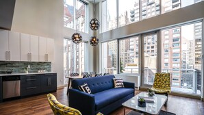 Un apartamento moderno con cocina, sala de estar y ventanas amplias con vistas a la ciudad.