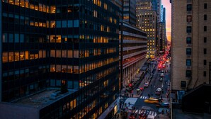 Un horizonte urbano con edificios altos, una calle concurrida y un paso de peatones.