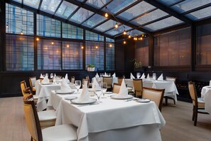 A restaurant with tables set for dining, featuring a glass ceiling and brick walls. - The Bernic Hotel New York City, Tapestry Collection by Hilton (New York)