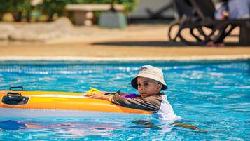 A child in a swimming pool using an inflatable raft.
