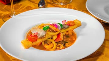 Un plato de mariscos sobre un mantel blanco y dorado.