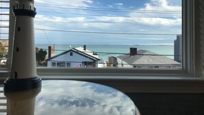 A view from a window with a lamp in the foreground, a clear sky, and buildings across the water. - The Winthrop Arms Hotel And Restaurant (Winthrop)