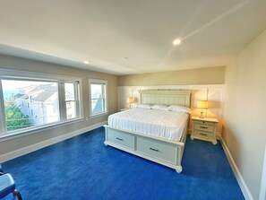 A bedroom with a large bed, two bedside tables, and a view of buildings through the windows. - The Winthrop Arms Hotel And Restaurant (Winthrop)