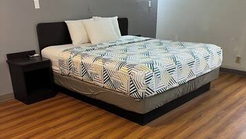 Un dormitorio con cama, mesita de noche y lámpara de pared.
