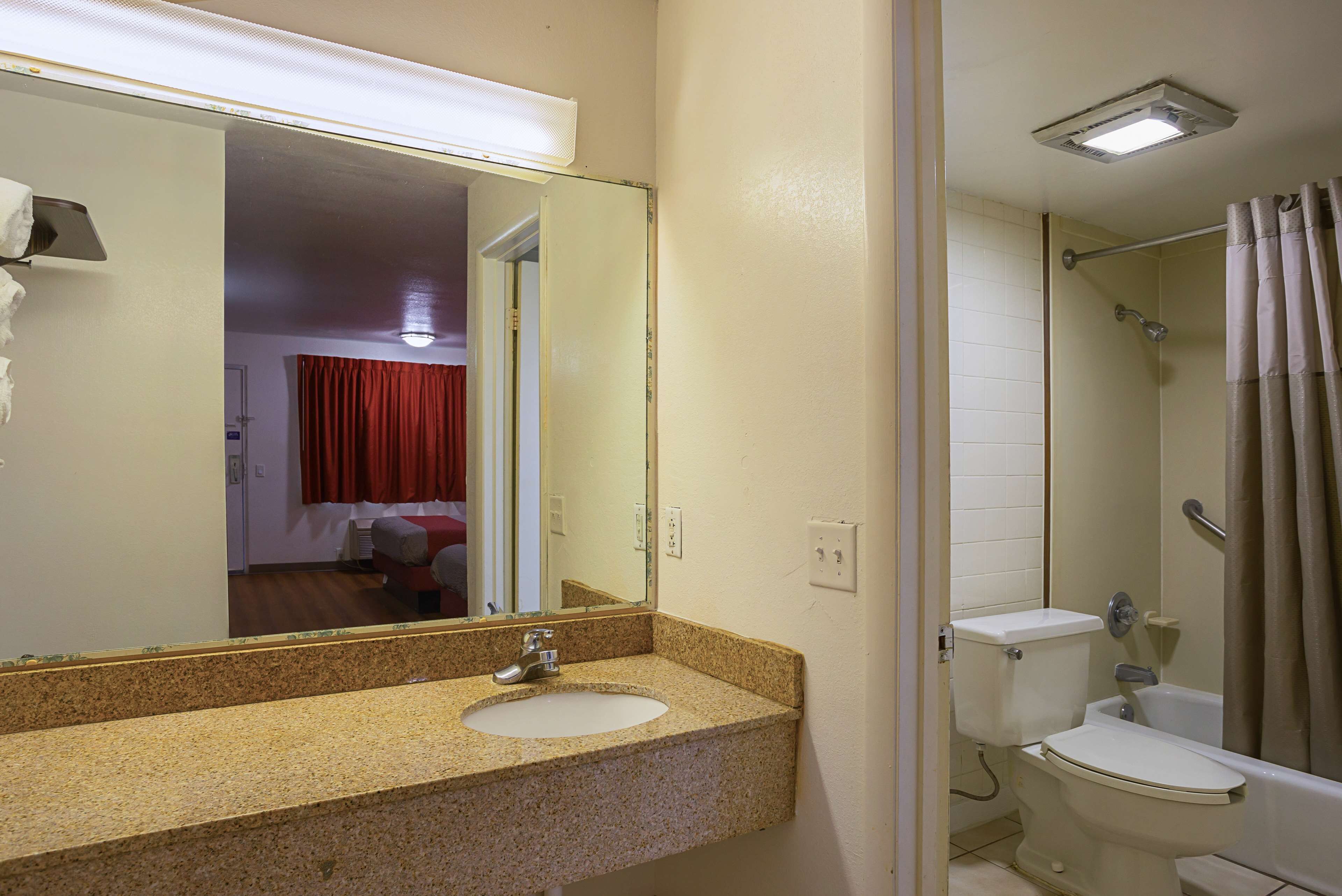 A bathroom with a sink, toilet, and shower.