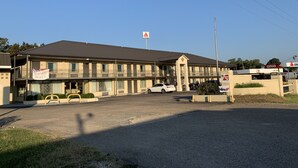 A motel with a two-story structure, a parking lot, and a CITGO gas station in the background.