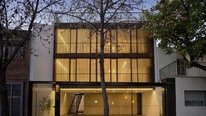 Un edificio moderno con un gran muro de cristal y una puerta metálica.