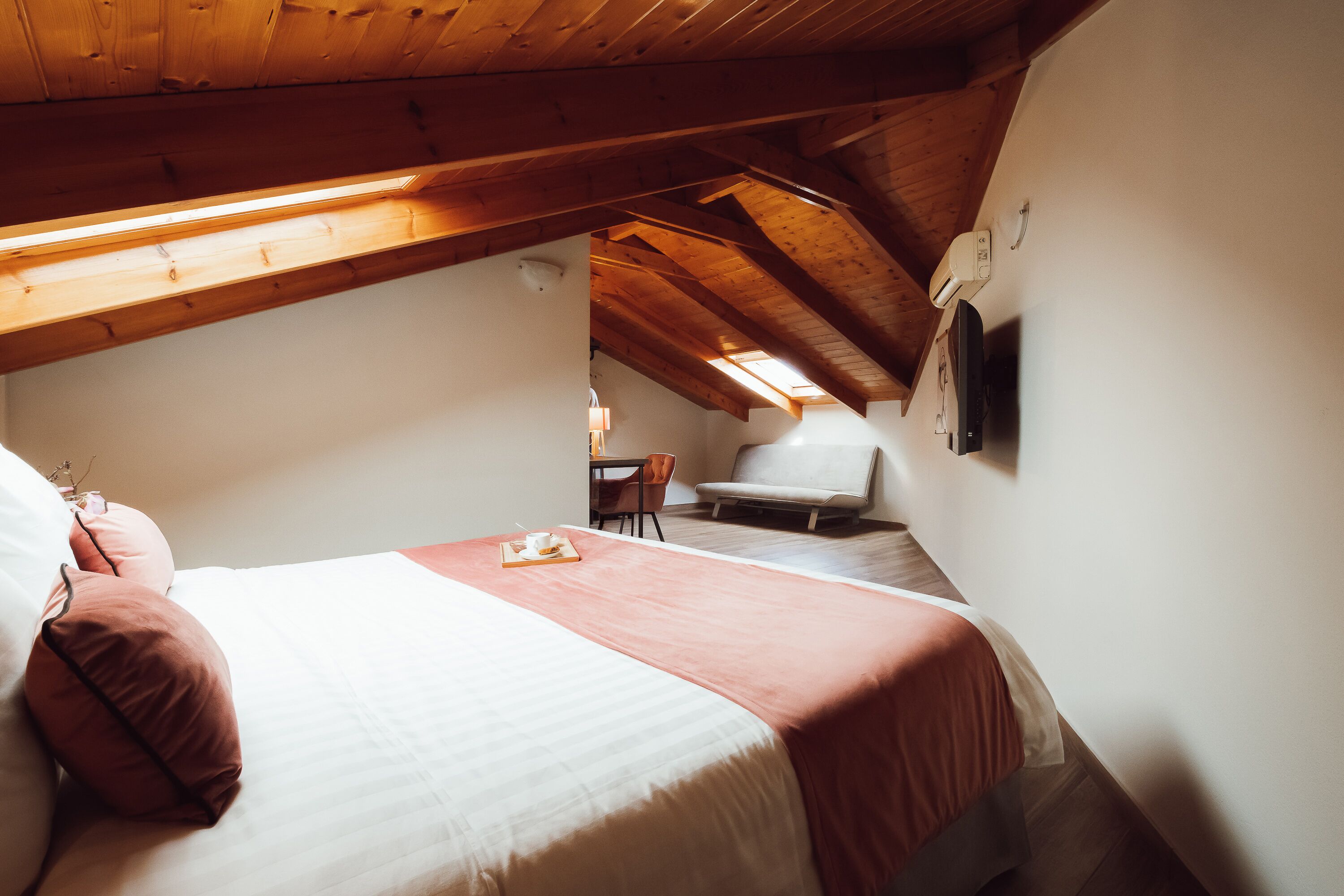 A bedroom with a bed, a chair, a table, and a ceiling fan.