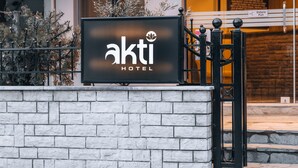 Een hotelschiltje met de naam 'akti HOTEL' en een poort met een duwbeugel.