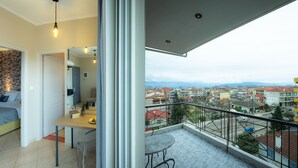 Un balcón con vistas a una zona residencial y montañas.
