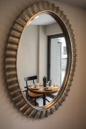 A round table with a chair, a small potted plant, and a glass of orange juice. - Nantin (Ioannina)