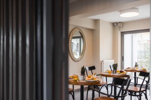 Un espace repas avec des tables rondes, des chaises et un grand miroir au mur.